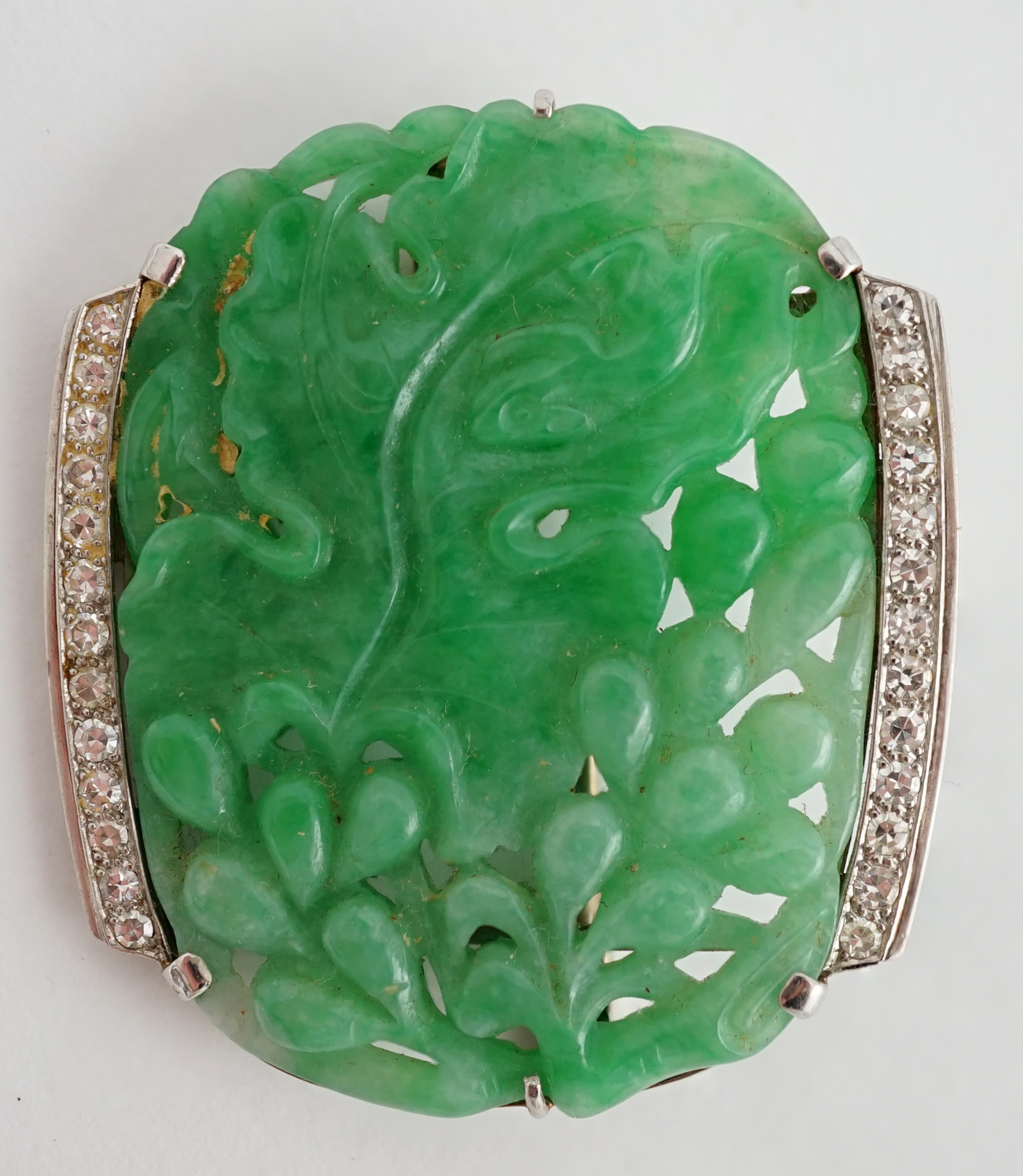 A Chinese white gold and diamond cluster set carved jade leaf and fruit brooch